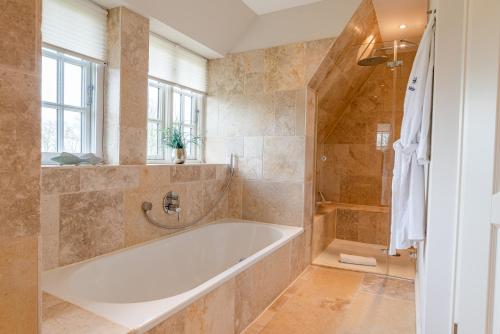 a large bathroom with a tub and a shower at Friesenliebe in Borgsum