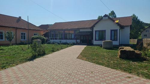 a brick driveway in front of a house at Casa Pelerinului in Bogata