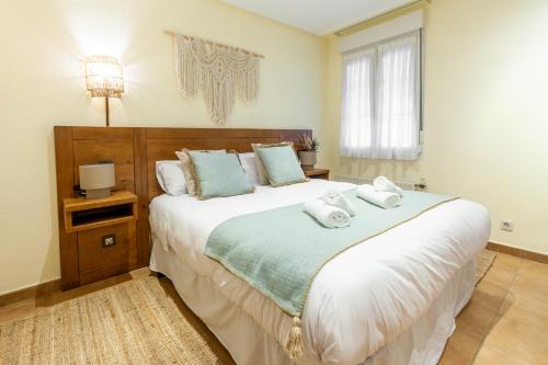 a bedroom with a large bed with towels on it at Habitaciones Guriezo in El Puente