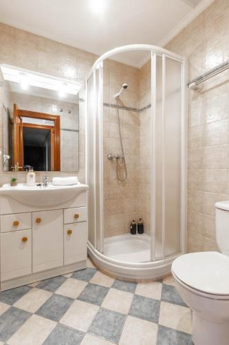 a bathroom with a shower and a toilet and a sink at Habitaciones Guriezo in El Puente