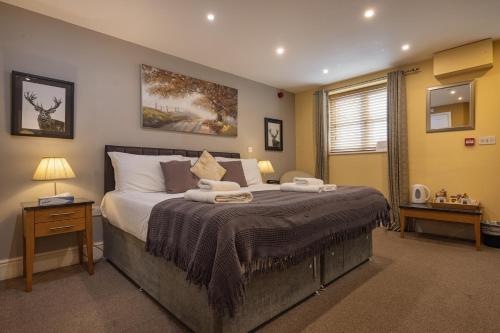 a bedroom with a large bed and a window at The Redesdale in Moreton in Marsh
