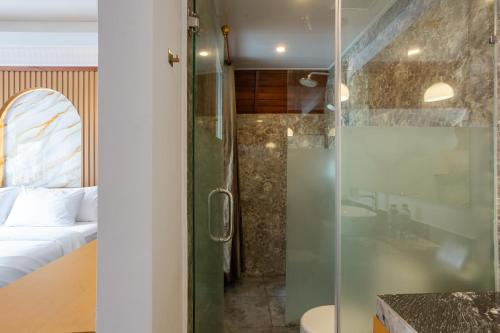a bathroom with a shower with a glass door at Merta Luwih Villa in Tanah Lot