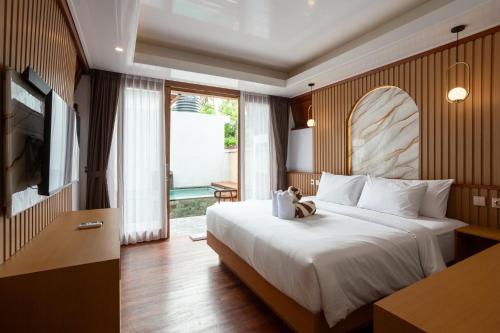 a hotel room with a bed and a television at Merta Luwih Villa in Tanah Lot