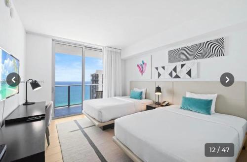 two beds in a room with a view of the ocean at Hyde house 3507 AL MAR in Hollywood