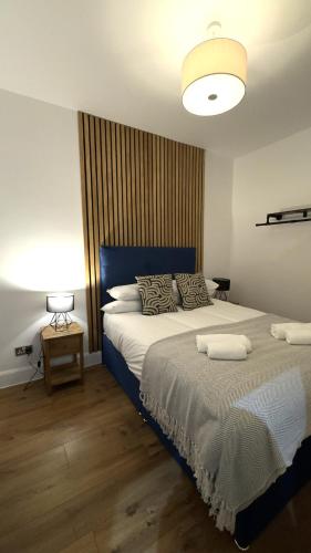 a bedroom with two beds with a blue headboard at Modern apartment in Edinburgh in Edinburgh