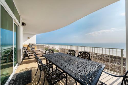 a balcony with a table and chairs and the ocean at Turquoise Place Beachside Retreat in Orange Beach