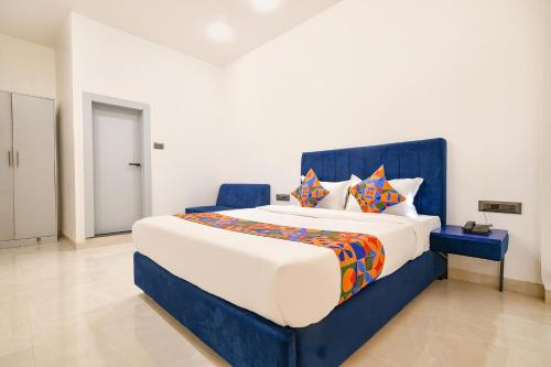 a bedroom with a large bed with colorful pillows at FabHotel Saraca Inn in Indore