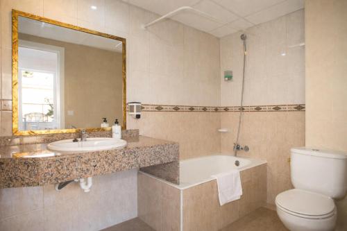 a bathroom with a sink and a toilet and a tub at Hotel OCTOPUS in Can Picafort