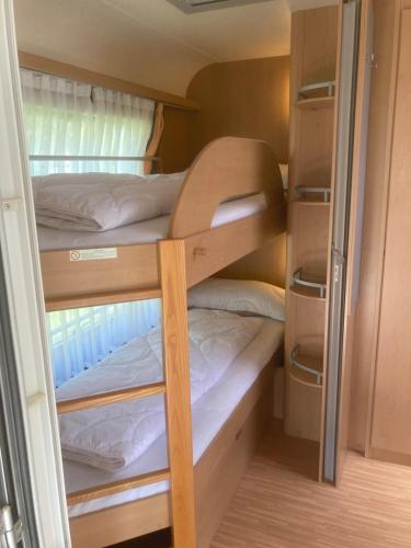 a small bedroom with two bunk beds in a caravan at Mietwohnwagen S1 am Flussufer in Wienhausen