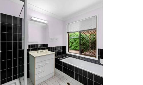 a bathroom with a tub and a sink and a window at Cozy Quiet Beach room R2 in Brighton
