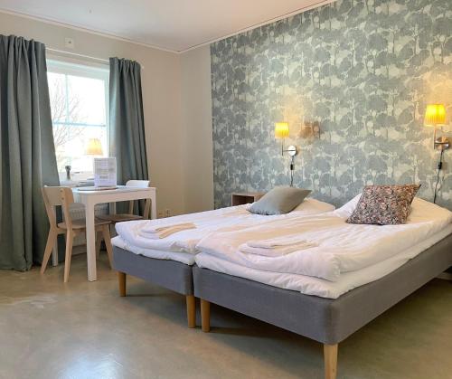 ein Schlafzimmer mit einem großen Bett in einem Zimmer mit einem Tisch in der Unterkunft Vita huset at Stora Le in Ed