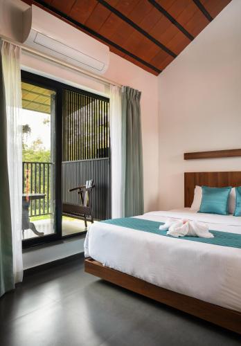 a bedroom with a bed and a large window at Punarjeevani Ayurvedic Heritage in Vythiri