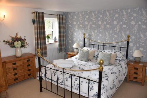 a bedroom with a black and white bed and a window at Pet Friendly, Border Cottage, Norfolk in Briston