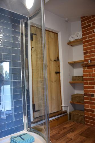 a shower with a glass door in a bathroom at Pet Friendly, Border Cottage, Norfolk in Briston