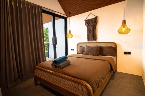 a bedroom with a bed and a large window at 2BR Villa Surrounded by Rice Fields Cemagi in Cemagi