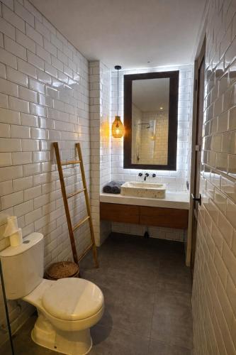 a bathroom with a toilet and a sink and a mirror at 2BR Villa Surrounded by Rice Fields Cemagi in Cemagi