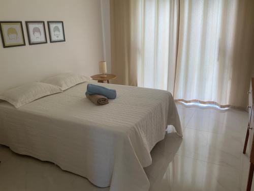 a bedroom with a white bed with a towel on it at Casa dos cajueiros in Paracuru