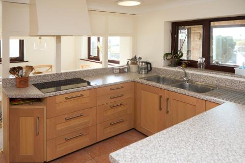 a kitchen with wooden cabinets and a sink at Dukes Well in Congleton