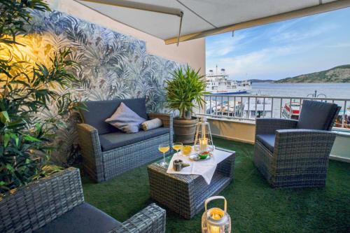 a patio with chairs and a table and a boat at Aquaemaris Apartment in La Maddalena