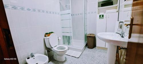 a white bathroom with a toilet and a sink at Lar da Rita - One bedroom apartment in Água Retorta