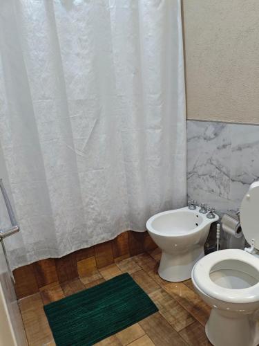 a bathroom with a toilet and a shower curtain at Depto 09 Condominio Totoras in Federación