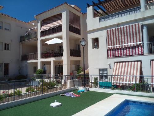 an apartment building with a swimming pool and a yard at Casa Joca Pueblo in Benalmádena