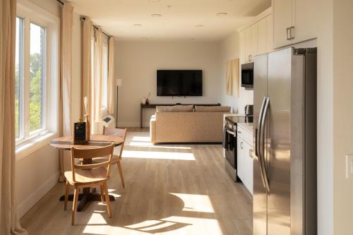 a kitchen and living room with a table and a refrigerator at Boardwalk Suites & Residences By Kasa in Traverse City