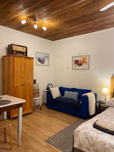 a living room with a blue couch and a table at Ov152 Apartman in Budapest