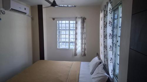 a bedroom with a bed and a window at JJ Comfort Hotel in Turuvekere