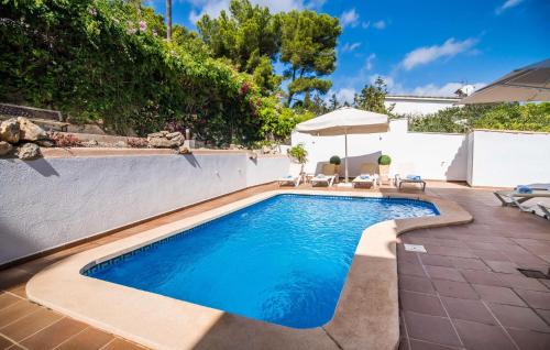 a pool in a backyard with chairs and an umbrella at Mar Bella Nou in Font de Sa Cala