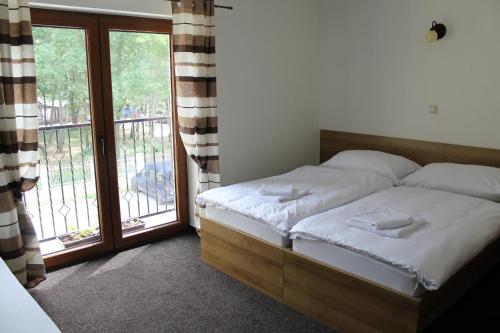 a bedroom with a bed and a large window at Penzión Gazarka in Šaštín