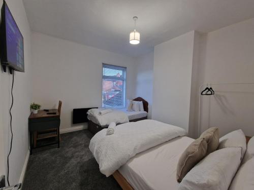 a room with two beds and a television in it at Nice Living Serviced Accommodations 14 in Coventry