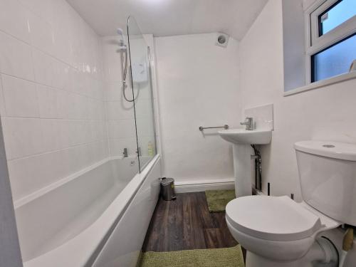 a white bathroom with a toilet and a sink at Nice Living Serviced Accommodations 14 in Coventry