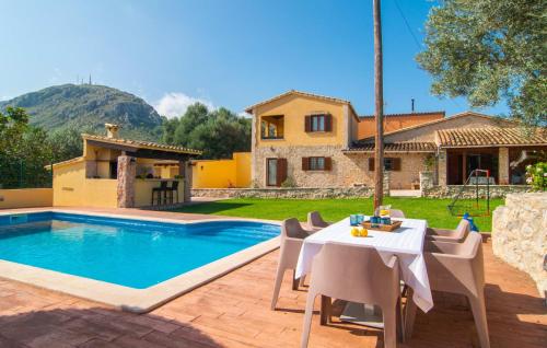 a villa with a table and chairs next to a swimming pool at Ca Na Conceda in Alcudia