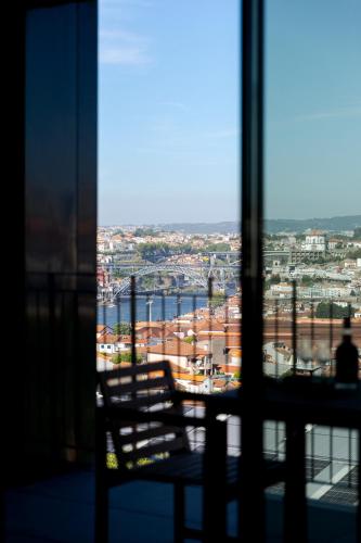 a window with a chair looking out at a city at Modern Porto Retreat by HostWise in Vila Nova de Gaia