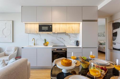 a kitchen with white cabinets and a table with food on it at Modern Porto Retreat by HostWise in Vila Nova de Gaia