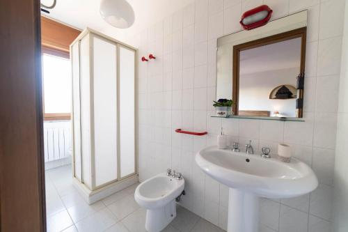 a white bathroom with a sink and a mirror at Casa Wanda IL MIRTO in Oristano