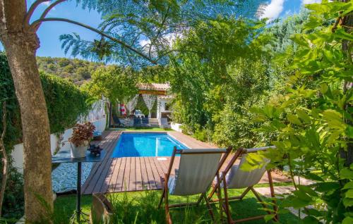 a garden with a swimming pool and two chairs at Casa Gema in El Port de la Selva