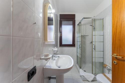 a white bathroom with a sink and a shower at Charme in Solèminis