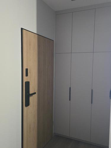 a wooden door in a room with white cabinets at Hotel-24 in Płock