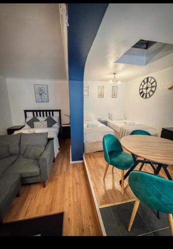 a room with two beds and a couch and a table at Dudy Studios At Brighton City Center in Brighton & Hove