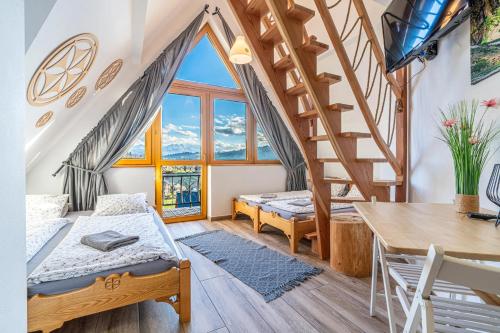 a bedroom with a bed and a staircase and a table at Góralski Przystanek Jacuzzi & sauna - dom dla 17 osób in Biały Dunajec