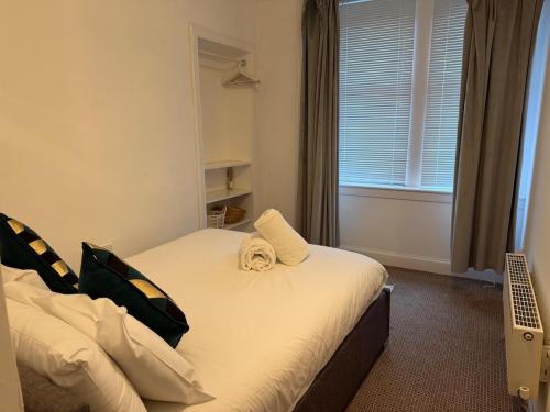 a bedroom with a bed with a towel on it at Stylish Glasgow Apartment in Whiteinch