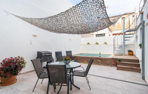 a patio with a table and chairs and a swimming pool at Petit Arta - Sa Botigueta in Artá