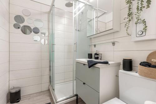 a white bathroom with a shower and a sink at Sea la Vie - Seitlicher Meerblick zwischen Südstrand und Yachthafen in Fehmarn