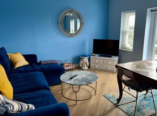 a blue living room with a blue couch and a table at Skyline Oasis in Portsmouth