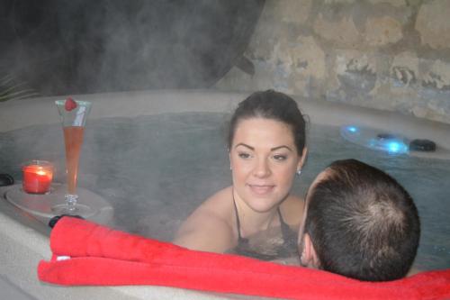 a woman and man in a bath tub with a drink at Un Air de Campagne in Couloisy