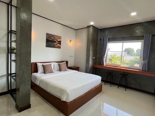 a bedroom with a bed and a window at 365 Place Maikhao in Ban Mai Salae