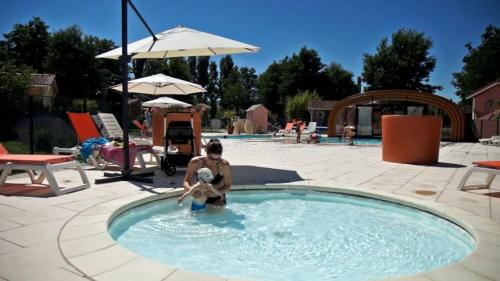 a man in a pool with a ball in the water at ZEcamping 3 étoiles Aveyron - Espace aquatique calme et nature in Montlaur