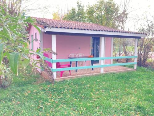 a pink and blue house with a deck at ZEcamping 3 étoiles Aveyron - Espace aquatique calme et nature in Montlaur